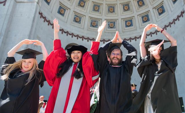 Ohio State graduates displaying O-H-I-O with their hands